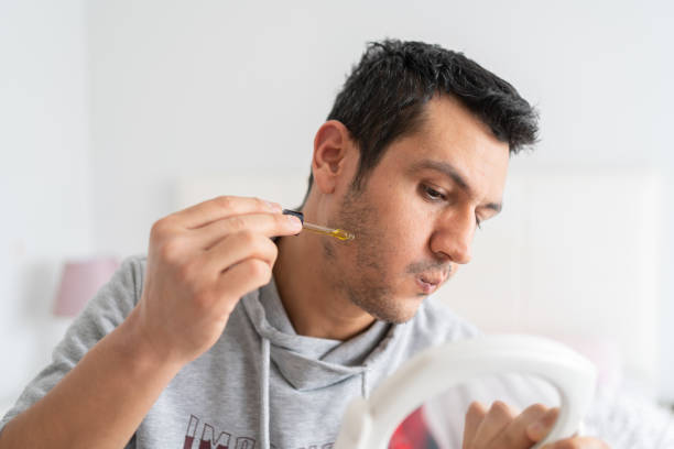 man applying serum to his balding beard